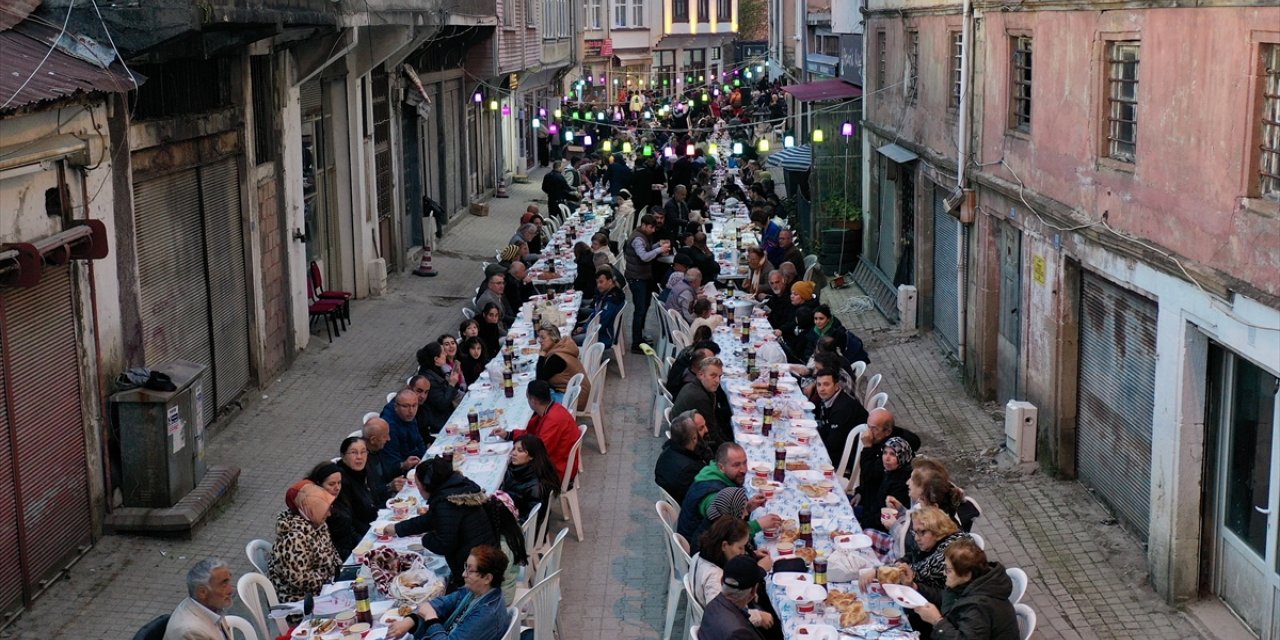 Mahalleli fazladan yaptığı yemekleri sokakta kurulan iftar sofrasında paylaşıyor