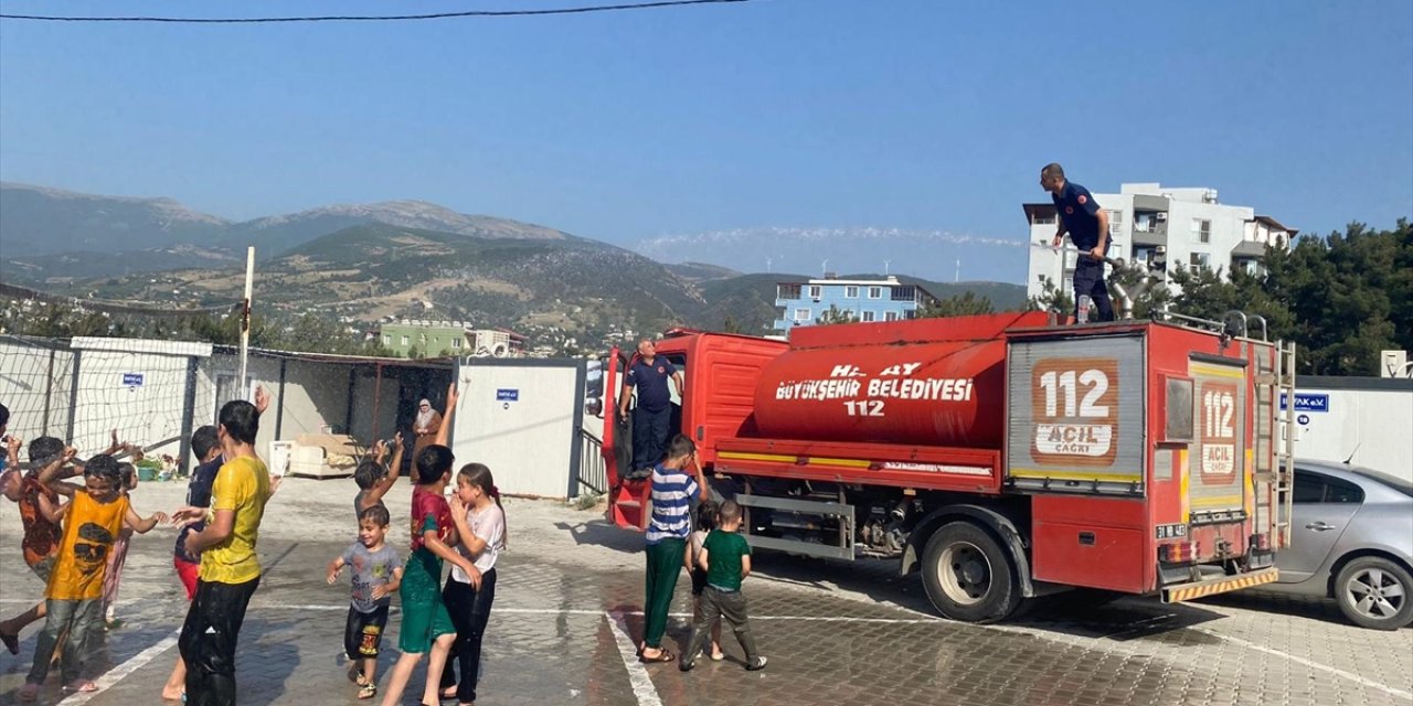 Hatay'da konteyner kentteki öğrenciler itfaiyenin sıktığı suyla serinledi