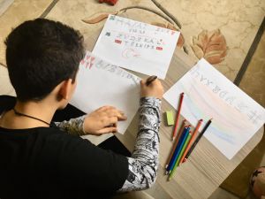 Çocuklar Kovid-19 tedbirlerine destek için aileleriyle çizdikleri resimleri camlara astı