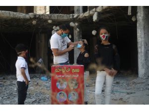 Gazzeli sanatçı, maske kullanımını teşvik için çocukların yüzlerini boyuyor