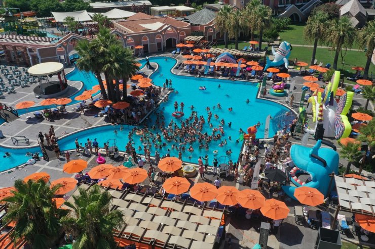 Antalya'da turistler sıcak havada havuza atılan buzlarla serinledi