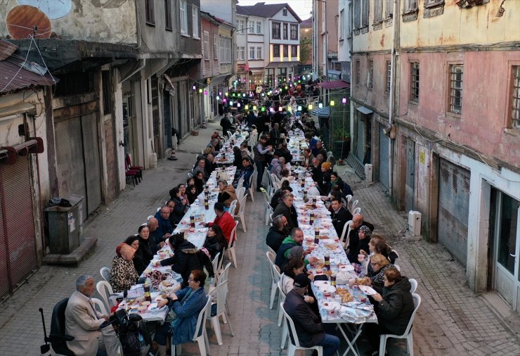 Mahalleli fazladan yaptığı yemekleri sokakta kurulan iftar sofrasında paylaşıyor