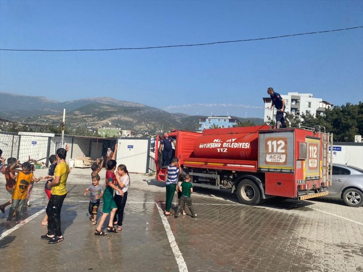 Hatay'da konteyner kentteki öğrenciler itfaiyenin sıktığı suyla serinledi