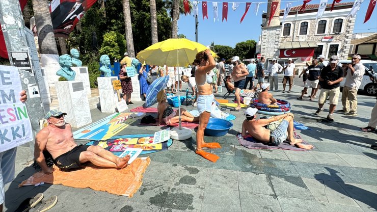 Bodrum'da kıyılarda denize giremediklerini öne süren bir grup belediye meydanında güneşlendi