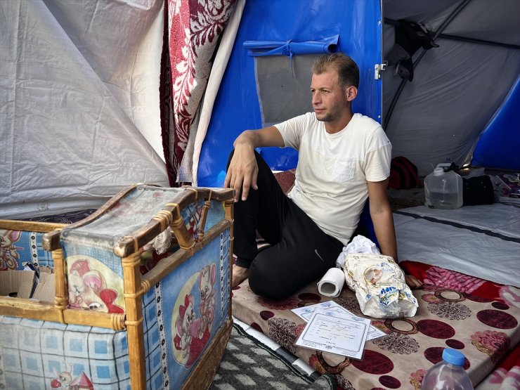 Filistinli baba, doğum belgelerini aldığı sırada öldürülen ikizlerinin kıyafetleriyle avunuyor