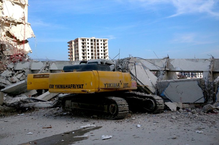 Hatay'da ağır hasarlı bina yıkım sırasında iş makinesinin üzerine devrildi